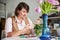 Pleased mature woman handcrafter staring at a new jewelry item