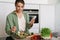 Pleased nice woman using mobile phone while preparing salad