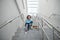 Pleased schoolboy sitting on stairs, reading book