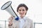 Pleased stylish brown haired businesswoman holding a megaphone