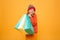 Pleased Young girl in sweater and hat holding packages