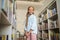 Pleased young lady standing in the school library