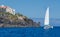 Pleasure catamaran sail close to the rocky shore