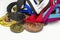 Plenty of shiny sport medals on different colorful ribbons isolated on white background