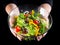 Plenty of wet cut vegetables in glass dish on woman hands