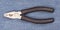 Pliers black handle tool isolated on blue jeans background