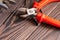 Pliers, side cutters, self-tapping screws on a wooden background, close-up, selective focus