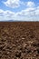 Plough plowed brown clay field blue sky horizon