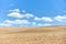 Ploughed arable plowing agricultural land plowed for crops under blue sky with clouds conceptual background with