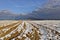 Ploughed farm land in the bacdrop as blue sky