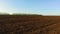 Ploughed field and blue the sky steadicam motion agriculture. Abstract perspective view to dark wide wet soil ways