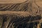 Ploughed field with dark earth and curved tracks