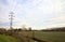 Ploughed field with an electricity pylon in the middle of it in the italian countryside in winter