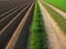 Ploughed soil beside way, agricultural background