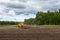 Ploughing Tractor At Field Cultivation Work. machine plows the field, harrows. The concept of agriculture and husbandry