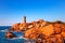 Ploumanach lighthouse sunset in pink granite coast, Brittany, Fr