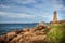 Ploumanach Mean Ruz lighthouse between the rocks in pink granite coast, Perros Guirec, Brittany, France