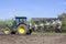 Plow behind tractor on dutch field in the netherlands in spring near utrecht