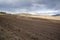 Plowed field, arable land, blue sky with clouds, landscape