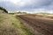 Plowed field, arable land, blue sky with clouds, landscape