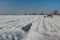 A plowed field covered with snow, horizon and sky