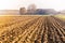 Plowed field and farm on hazy day