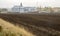 Plowed field in front of the elevator for grain storage. Grain warehouse