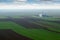 Plowed and green wheat fields and grain tank