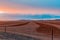 Plowed red field at colorful sunrise.