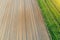 Plowing land furrows for planting agronomical plants among the countryside of grass and meadows trees, aerial view from above