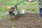 Plowing a plot for gardening with a gasoline cultivator with special wheels