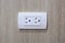 Plug Into Electricity Socket the power outlets on the wood wall.