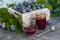 Plum jam in a jar. In the background there are plums. Tkemali sauce. Preparing for winter. Light background.