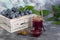 Plum jam in a jar. In the background there are plums. Tkemali sauce. Preparing for winter. Light background.