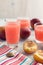 Plum juice. Pink drink on a white wooden table with striped napkin.