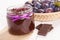 Plum marmalade or jam in glass jar, fruits in wicker basket and chocolate, sweet dessert concept