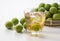 Plum wine and unripe plums on a white background