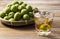 Plum wine and unripe plums on a wooden background