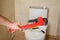 Plumber holding pipe wrench near toilet indoors,