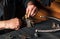 The plumber inserts the brass fittings into a vise. Close-up of a foreman is hand while working in workshop.