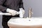 A plumber installs a siphon for a wash basin in a bathroom