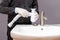 A plumber installs a siphon for a wash basin in a bathroom