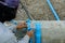 Plumber man worker install blue pvc pipe connect on cement beam for infrastructure building house. professional labor installer an