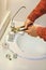 Plumber tightens leaky faucet