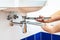 Plumber unscrews sink siphon by two pipe-wrenches