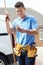 Plumber With Van Texting On Mobile Phone Outside House