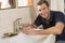 Plumber working on sink smiling