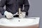 A plumber with a wrench in his hand installs a faucet on a sink in a bathroom