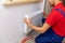 Plumbing services - plumber installing heating radiator on the w