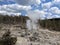 Plume of steam rising high from rocks at Yellowstone National Park